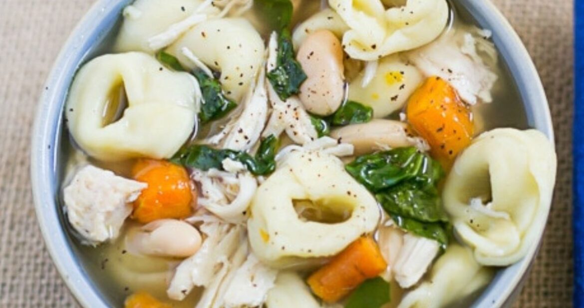 Overhead image of a bowl filled with crock pot chicken tortellini soup.