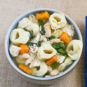 Overhead image of a bowl filled with crock pot chicken tortellini soup.