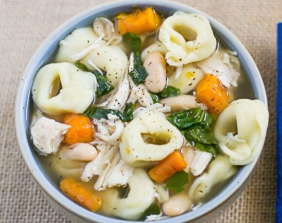 Overhead image of a bowl filled with crock pot chicken tortellini soup.