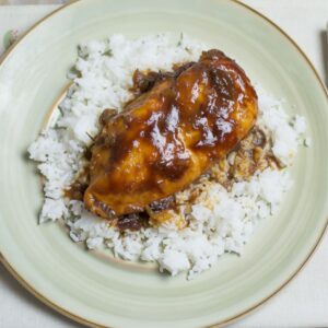 Crock Pot Boneless chicken cooked in cranberry and bbq sauce on a plate.