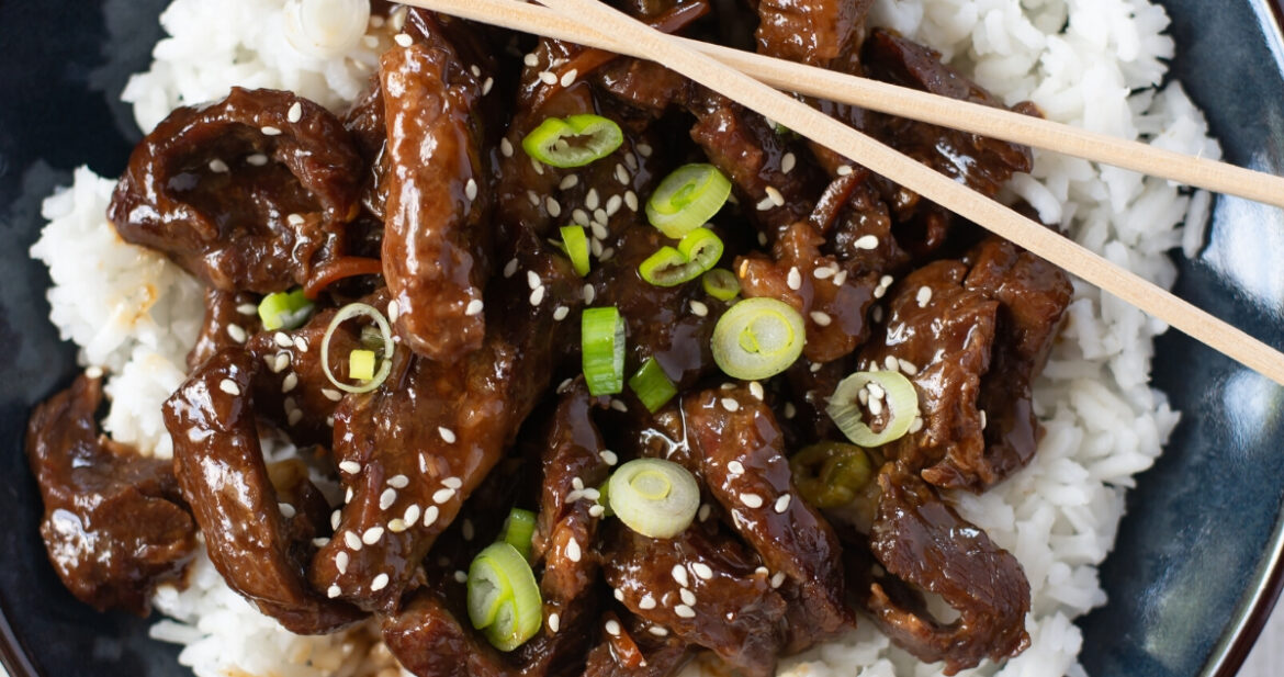 a serving of mongolian beef over white rice is a bowl