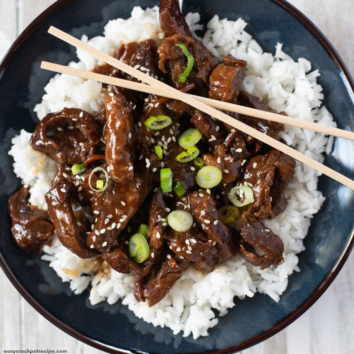 a serving of Mongolian beef over white rice is a bowl.