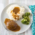 Salisbury Steak served with mashed potatoes and gravy.